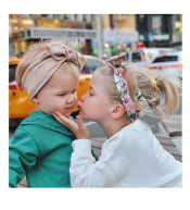 Dziewczynka w jasnobeżowej opasce dziecięcej UL&KA Twistula, delikatna pleciona tkanina, stylowy i wygodny model